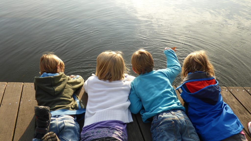 Children on a dock at lake. Playtime therapy is a form of children's counseling. 