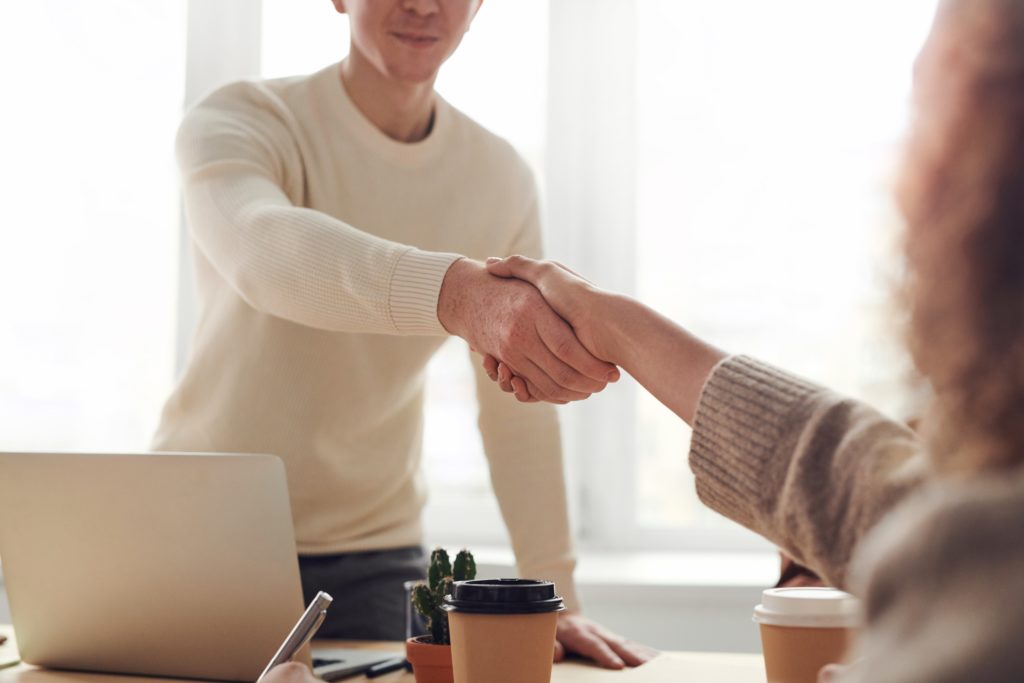 Two people shaking hands to form a partnership for better mental health in Colorado.