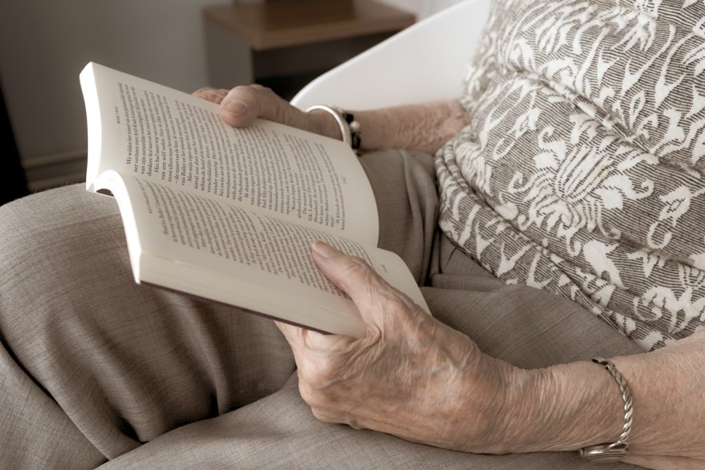 hands holding both sides of a book representing reading for relaxation